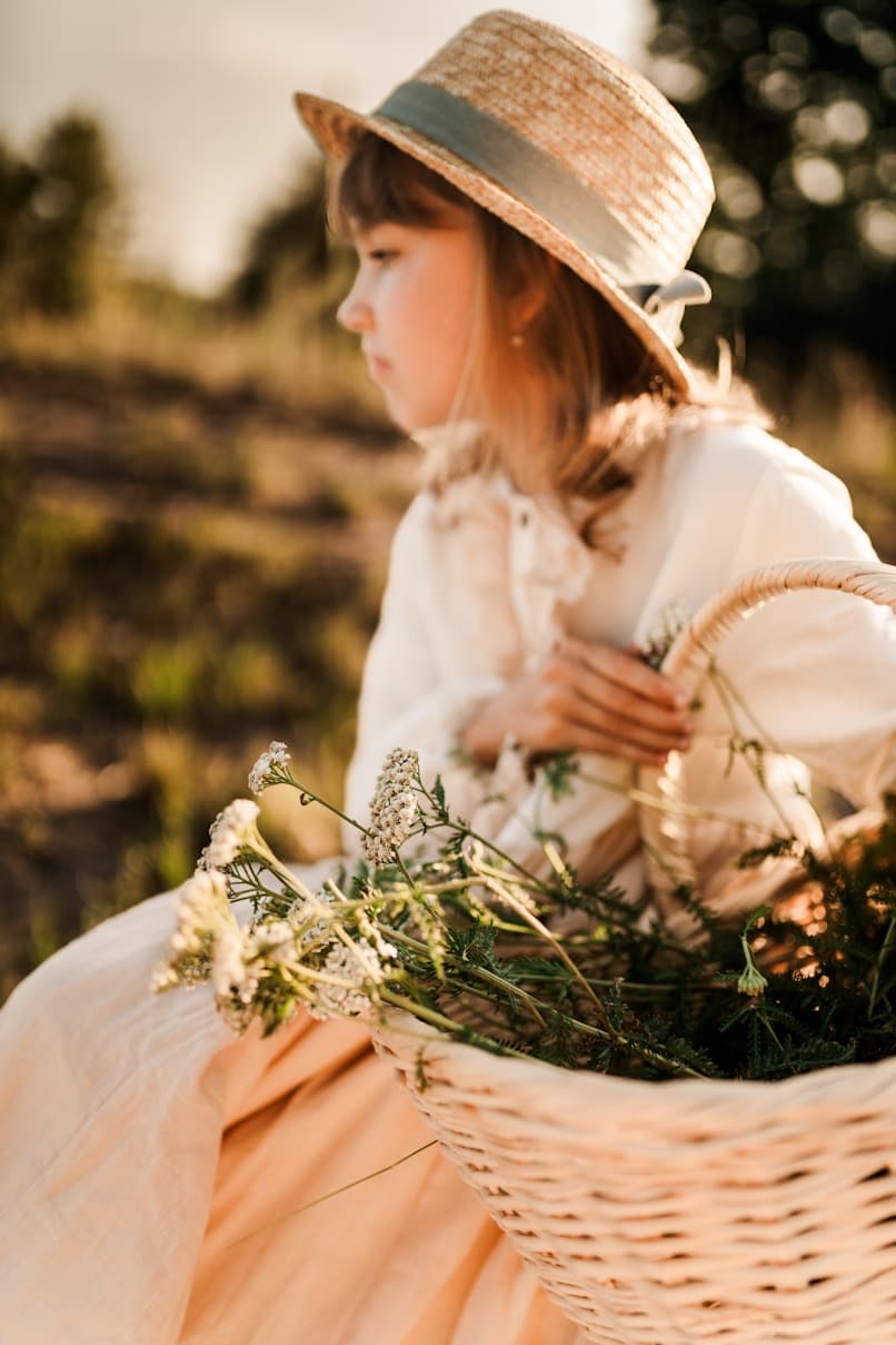Girl wearing straw hat with flower basket